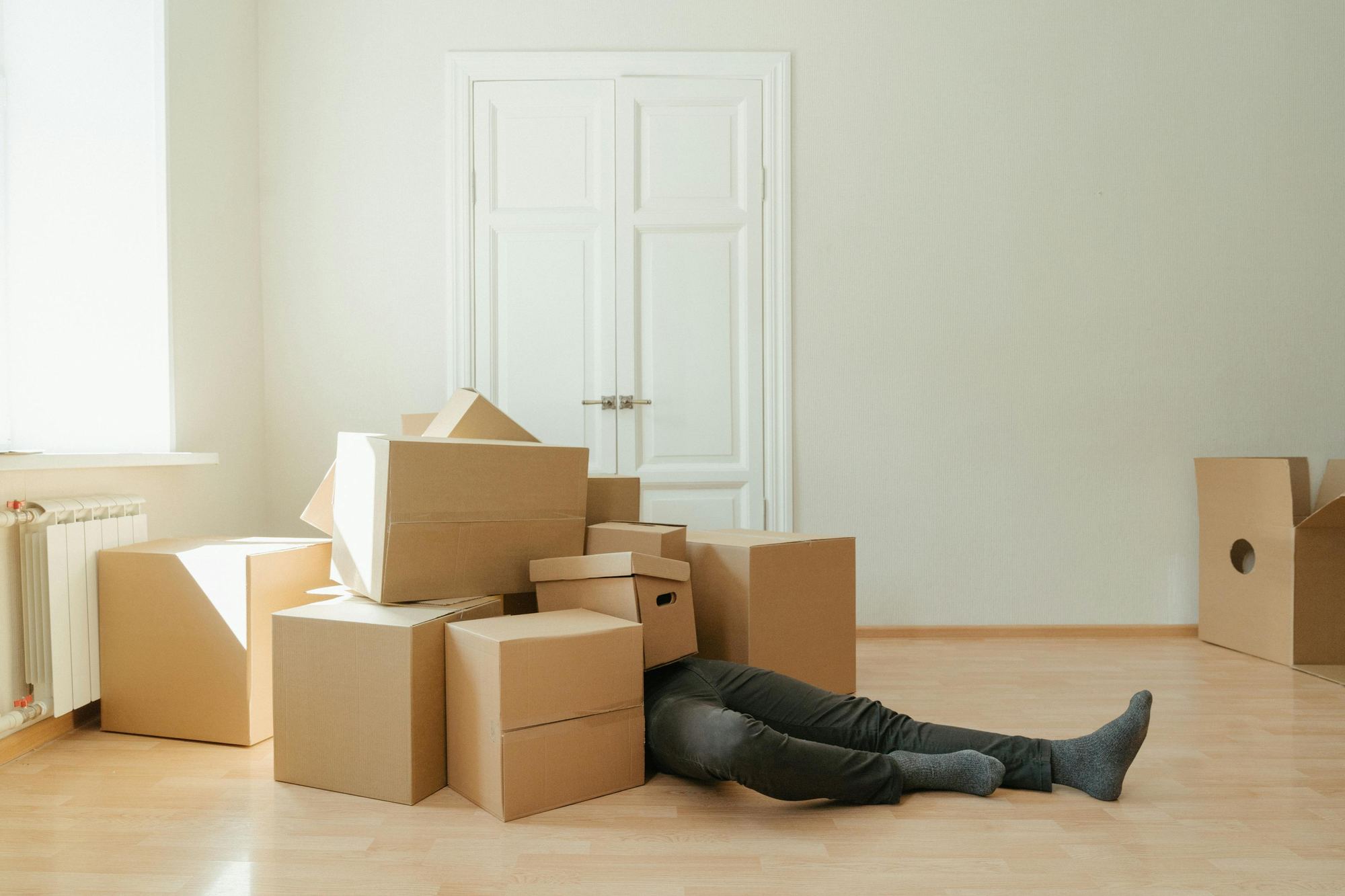 Cardboard moving boxes stacked in an empty room ready for a house move